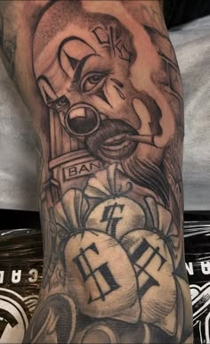 a man's leg with tattoos on it and an image of a clown in the background