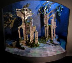 a model of a castle with trees and bushes on it's display stand in front of a blue background