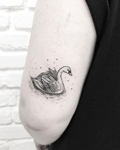 a black and white swan tattoo on the left arm