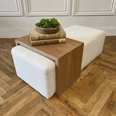 a wooden table topped with a plant on top of a white ottoman