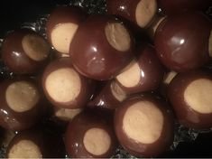 chocolate covered candies in foil wrapper on black table top, close up view