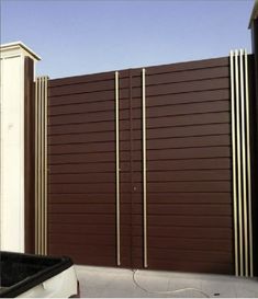 a large brown gate next to a building