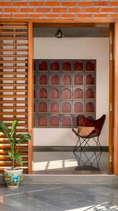 a chair sitting on top of a cement floor next to a brick wall and door