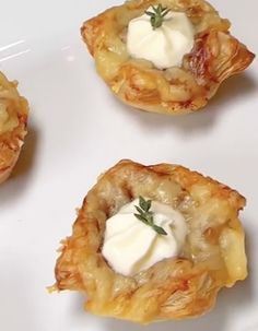 four appetizers on a white plate topped with sour cream