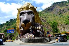 a large statue of a lion with its mouth open in the middle of a street