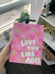 someone holding up a pink book with hearts on it that says love you like aoit