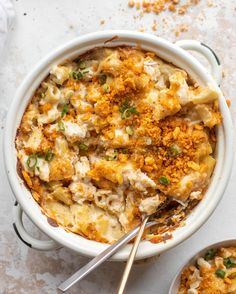 two bowls filled with macaroni and cheese on top of a white tablecloth