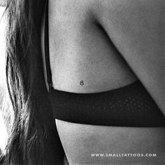 black and white photograph of woman's back with small tattoo on her left side