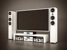 an entertainment center with speakers and a large screen television on it's stand, in front of a dark background