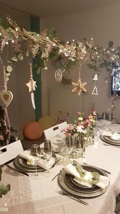 the table is set with plates, silverware and flowers in vases on it