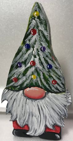 a ceramic christmas tree decoration with lights on it's head and beard, sitting on a shelf