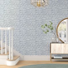 a living room with blue wallpaper and a round mirror on the side table in front of it