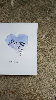 a piece of paper with the word love written on it and a heart shaped balloon