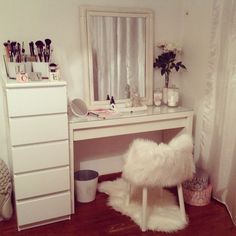 a white desk with a mirror, stool and other items on top of the table