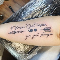 a woman with a tattoo saying it doesn't get easier, you get longer