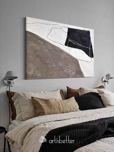 a bed with white sheets and pillows in a bedroom next to a painting on the wall