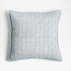 a light blue pillow sitting on top of a white wall