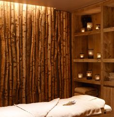 a spa room with wooden shelves and candles