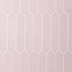 a white tiled wall with hexagonal tiles on the top and bottom half, in various shades of pink