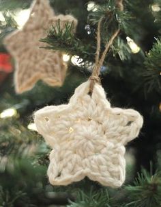 a crocheted star ornament hanging from a christmas tree