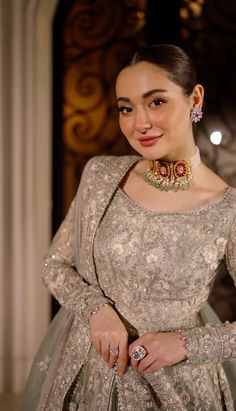 a woman in a dress and jewelry poses for the camera