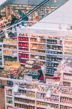 an open market filled with lots of food and people walking through the aisles, some on escalators