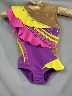 a purple, yellow and pink leotard with sequins on the bottom