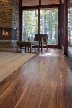 a living room filled with furniture and a fire place in front of a large window