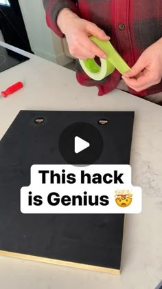 a person cutting up a piece of black paper on top of a counter with scissors