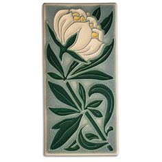 a white flower with green leaves is on a gray and blue tile wall hanging ornament