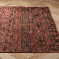 an old rug is laying on the floor in front of a wood flooring area