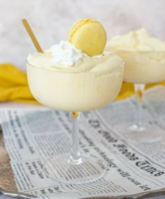 two desserts sitting on top of a newspaper next to each other in coupe glasses