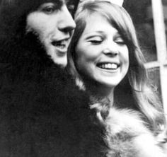 an old black and white photo of two people with long hair smiling at the camera