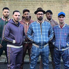 a group of men standing next to each other in pajamas and hats on the street