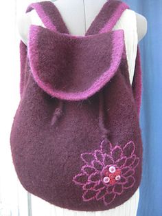 a purple bag with a flower on it is sitting on a mannequin's dummy