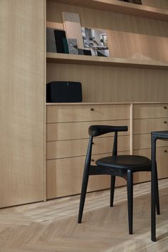 two black chairs sitting in front of a bookshelf