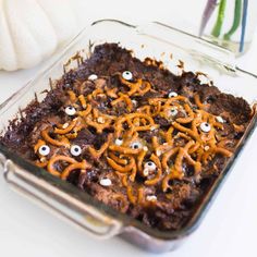 a glass casserole dish filled with chocolate and sprinkles decorated with googly eyes