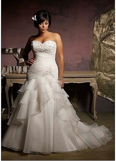 a woman in a wedding dress posing for the camera