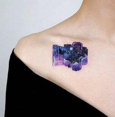 a woman's chest with an abstract piece of art on her left side shoulder