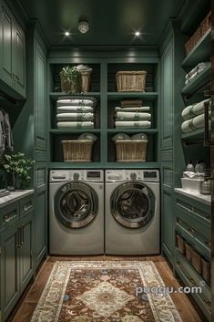 a washer and dryer in a green laundry room with lots of towels on the shelves