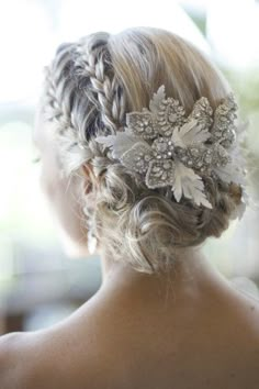 the back of a woman's head wearing a wedding hair comb with flowers in it