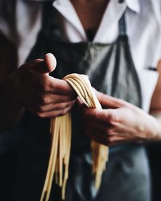 a person holding some noodles in their hands