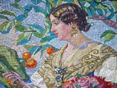 a woman with flowers in her hair is depicted on a mosaic tile wall that features leaves and branches