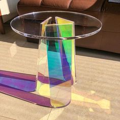 a table that has some kind of colorful object on it's top and is next to a couch