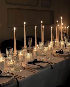 a long table is set with candles and place settings for an elegant dinner or party