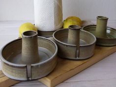 four bowls and two rolls of toilet paper on a wooden tray with some lemons in the background