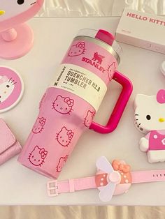 a hello kitty water bottle and other items on a white tablecloth with pink ribbon