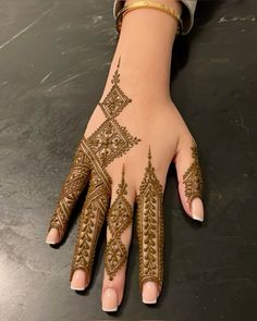 a woman's hand with henna tattoos on it