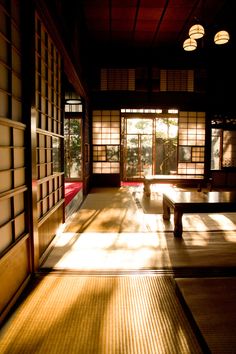 the sun is shining on an empty room with tatami mats and tables in it