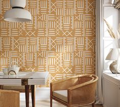 a table and chairs in front of a wallpapered room with an orange pattern